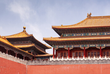 Beijing, China - April 27, 2010: Forbidden City. Meridain Gate corner and other buildings seen over red wall under blue sky. Chinese architecture.