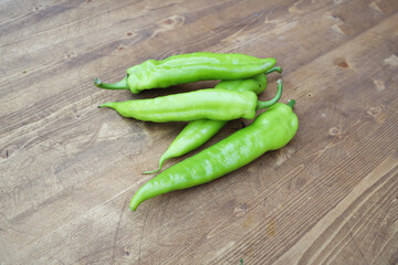 green pepper pods on a wooden table