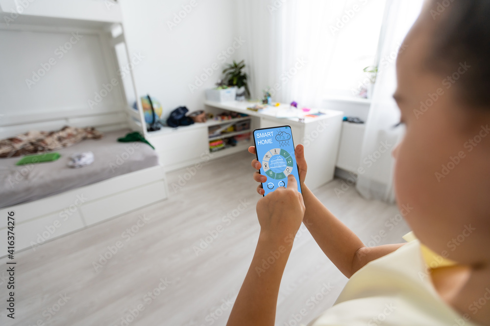 Poster shot of little girl using a domotic system with her digital tablet while standing at home.