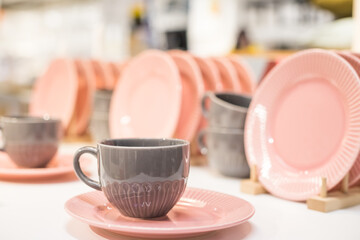 Commercial pink and white plates and bowls stacked with crystal wine glasses.Colorful ceramic clean dishware.Ceramic crockery tableware