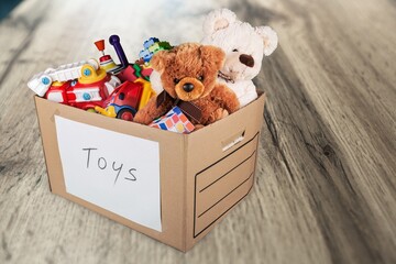 Toys collection in card box on the wooden floor