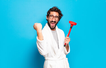 young bearded man wearing bathrobe with a plunger