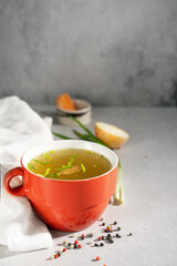 hot homemade beef bone broth with collagen and amino acids in red bowl
