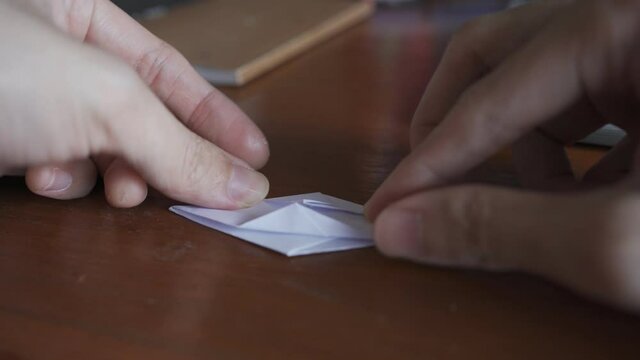 Folding origami crane from white paper