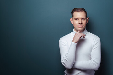 Think about solutions. Studio portrait of thoughtful young man on blue background.