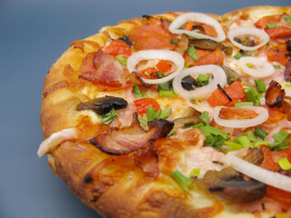 fresh whole pizza with mushrooms, pepperoni sausage and onions