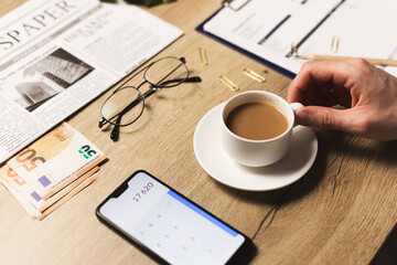 Businessman is calculating balance, expected profit or expenses with smartphone. Business plan and self accounting concept