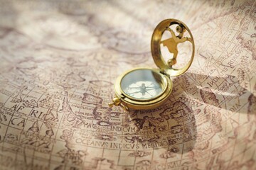 Retro styled golden compass (sundial) and old white nautical chart. Vintage still life. Sailing...