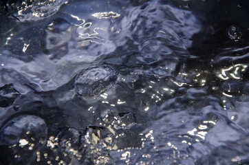 Surface of intensive boiling water with bubbles and swirls