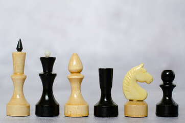 Side view of black and white chess pieces on a chessboard
