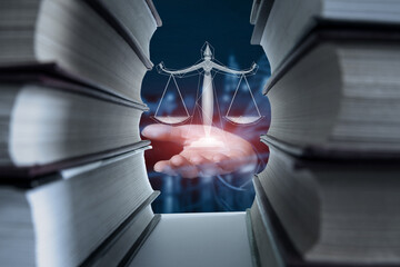 Hand shows the scales of justice between the books .