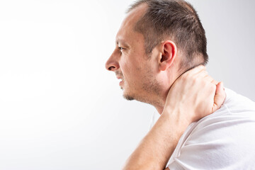 Obraz premium Side view middle aged Man Feeling Painful Neck Ache, Touching Face With Hand. man having a Neck pain. Isolated on white background. Patient with neck ache in medical office