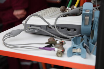 Portable electrocardiograph on table in ambulance car, digital ECG system for Cardiologist doctor for for quick diagnostics of cardio diseases, first aid equipment set