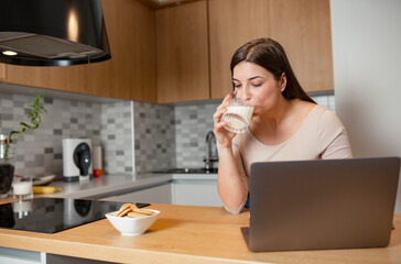 Woman eat breakfast and using laptop at morning