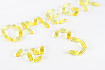Yellow medicine capsule, omega 3 pills, vitamin E health treatment, fish fat for skin hair care on...
