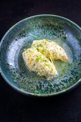 Modern style traditional quenelles de brochet fish in white wine sauce broth in ceramic Nordic...