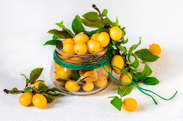 Ripe yellow plums in a glass jar.Soft focus