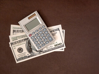 Calculator, coins and banknotes on a dark background. The idea of business, Finance concept and saving money and time