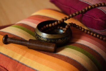 Tibetan bowl with a mala on a nice colorful cushion