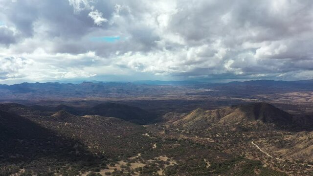 The borderlands between Arizona and Mexico as seen from the U.S. side in the Coronado National Forest east of Nogales, AZ. The border wall and Nogales, Mexico are seen in the distance. Aerial shot.