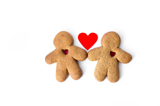 A pair of gingerbread lovers with hearts isolated on a white background. Christmas cookies with love. 