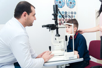 Boy with mom on eye examination by ophthalmologist