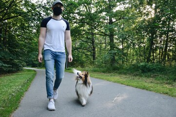 Man in mask walking his dog