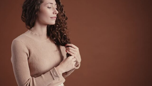 MS CU Studio portrait of young woman with long curly hair