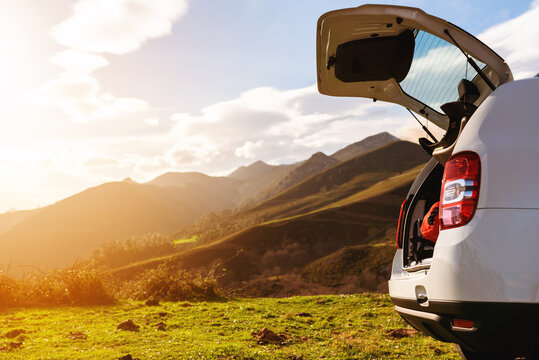 Open off-road car trunk with luggage inside on a mountain at sunset. holidays and weekends. Active turism.