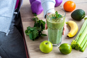 Healthy habits for a healthy woman's life. Sportswoman drinks green smoothie, cocktail, juice