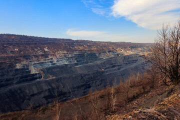 Huge iron ore quarry with working dump trucks and excavators