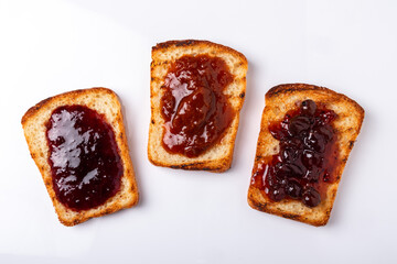 slices of bread with different kinds of jam spread on them on a white background top view