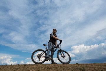 Fototapeta na wymiar Sports brutal bearded guy on a modern mountain bike. A cyclist in a salt deserted place by the lake.