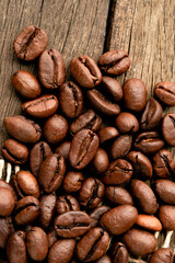 Closeup, top view of coffee beans over rustic wooden table