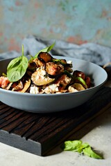 Baked eggplant with tomatoes, onion and feta cheese. Vegetable side dish. Mediterranean dish. Ratatouille french provence dish of vegetables. Healthy tasty food, vegetable ragout.  Hard shadows