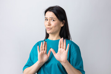 Portrait of uncomfortable pretty brunette, raising palms in stop gesture. That is enough, thanks.