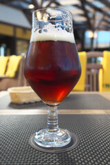 A glass of dark beer in a summer cafe.