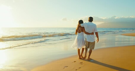 Happy romantic couple enjoying relaxing sunset walk on the beach, travel vacation lifestyle.