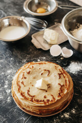 Baking products for making pancakes - Russian traditional cuisine: milk, eggs, flour, butter, на темном фоне