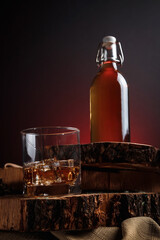 Ice cubes in a whiskey glass. Strong alcohol. Stand made of wood.