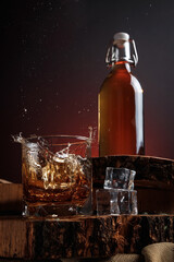 Old whiskey bottle on black wooden table. Drinks on a dark blurred background.