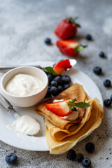 Pancakes with fresh strawberries and blueberries. National Russian cuisine, the holiday of Maslenitsa.
