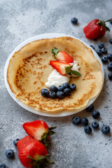 Pancakes with fresh strawberries and blueberries. National Russian cuisine, the holiday of Maslenitsa.