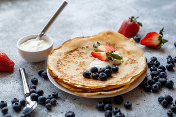 Pancakes with fresh strawberries and blueberries. National Russian cuisine, the holiday of Maslenitsa.