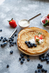 Pancakes with fresh strawberries and blueberries. National Russian cuisine, the holiday of Maslenitsa.