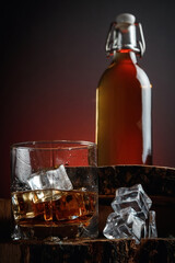 Old whiskey bottle on black wooden table. Drinks on a dark blurred background.