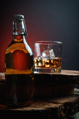 Ice cubes in a whiskey glass. Strong alcohol. Stand made of wood.