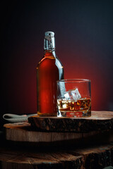 Ice cubes in a whiskey glass. Strong alcohol. Stand made of wood.