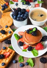 Pancakes with blackberries, raspberries and straberries. American cuisine. Coffee and waffles. Dessert. Recipes Breakfast