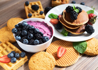Pancakes with fresh berries. Breakfast setting. Cottage cheese, waffles and coffee.